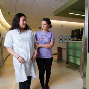 Doula walking with a patient in the hallway