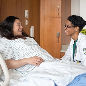 Doctor and patient laughing during bed side visit